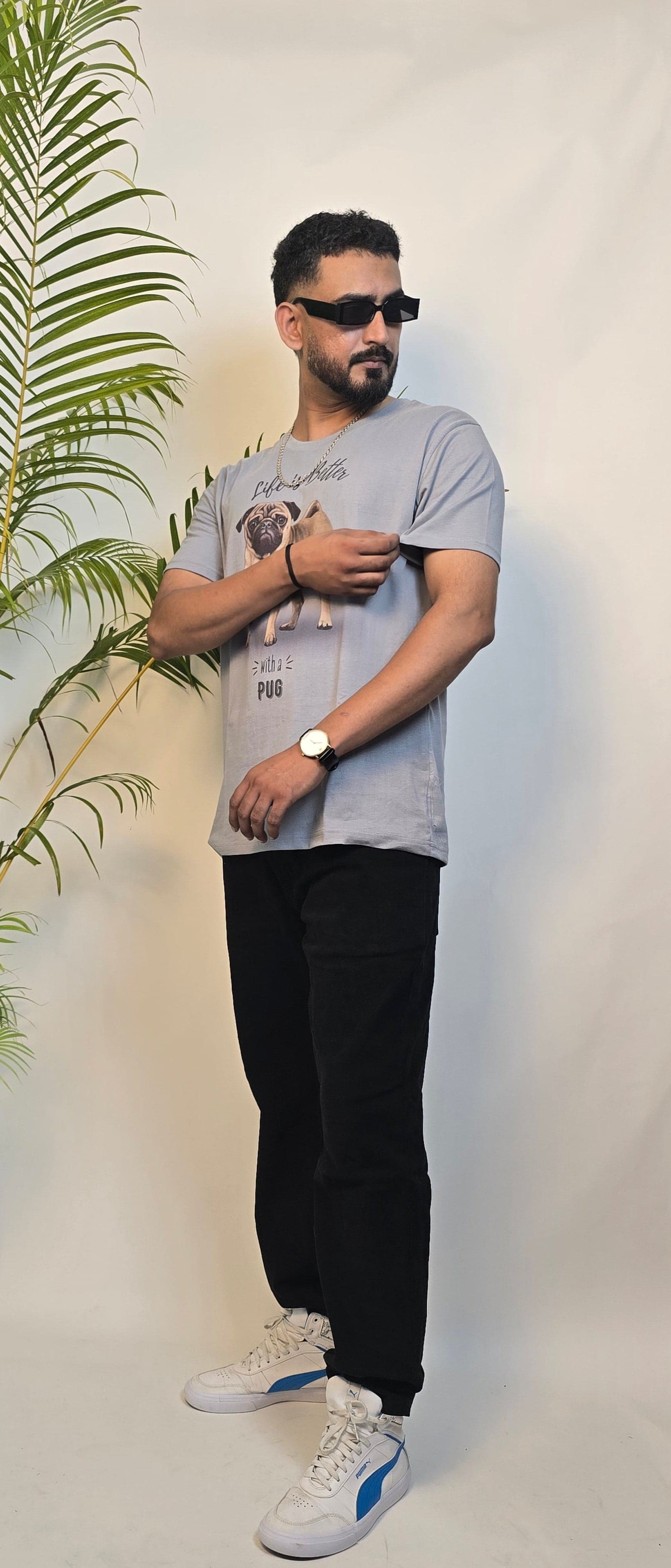 Man standing next to a large roll of paper with a plant on a white floor.