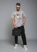 Person holding a black bag in a minimalistic indoor setting with plants.