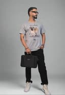 Person holding a black bag in an indoor setting with plants and a white wall.