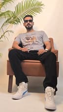 Two people sitting on a bench with a plant in the background