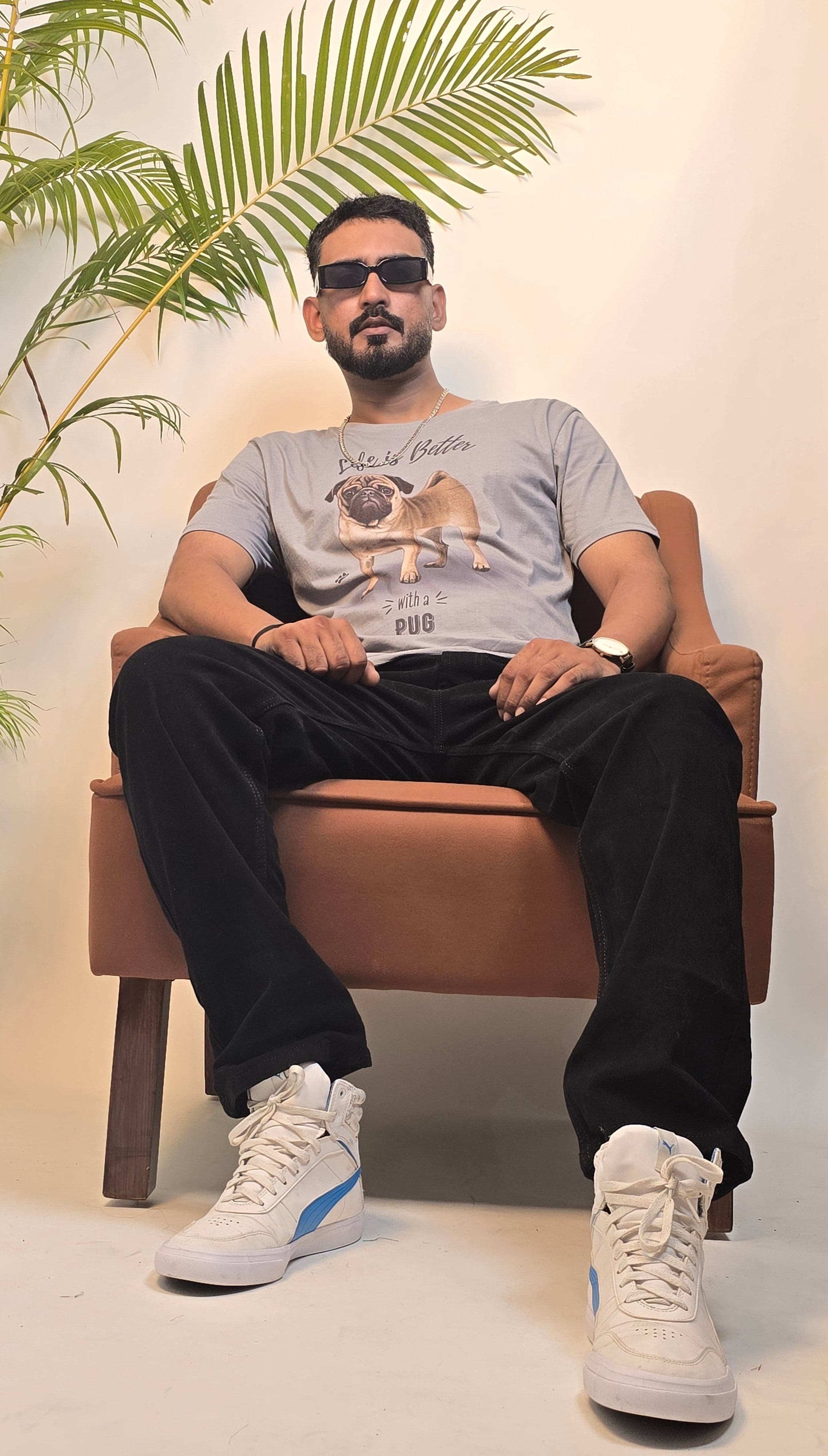 Two people sitting on a bench with a plant in the background