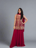 Woman in a red and gold dress lying on a textured floor with a colorful painting in the background.