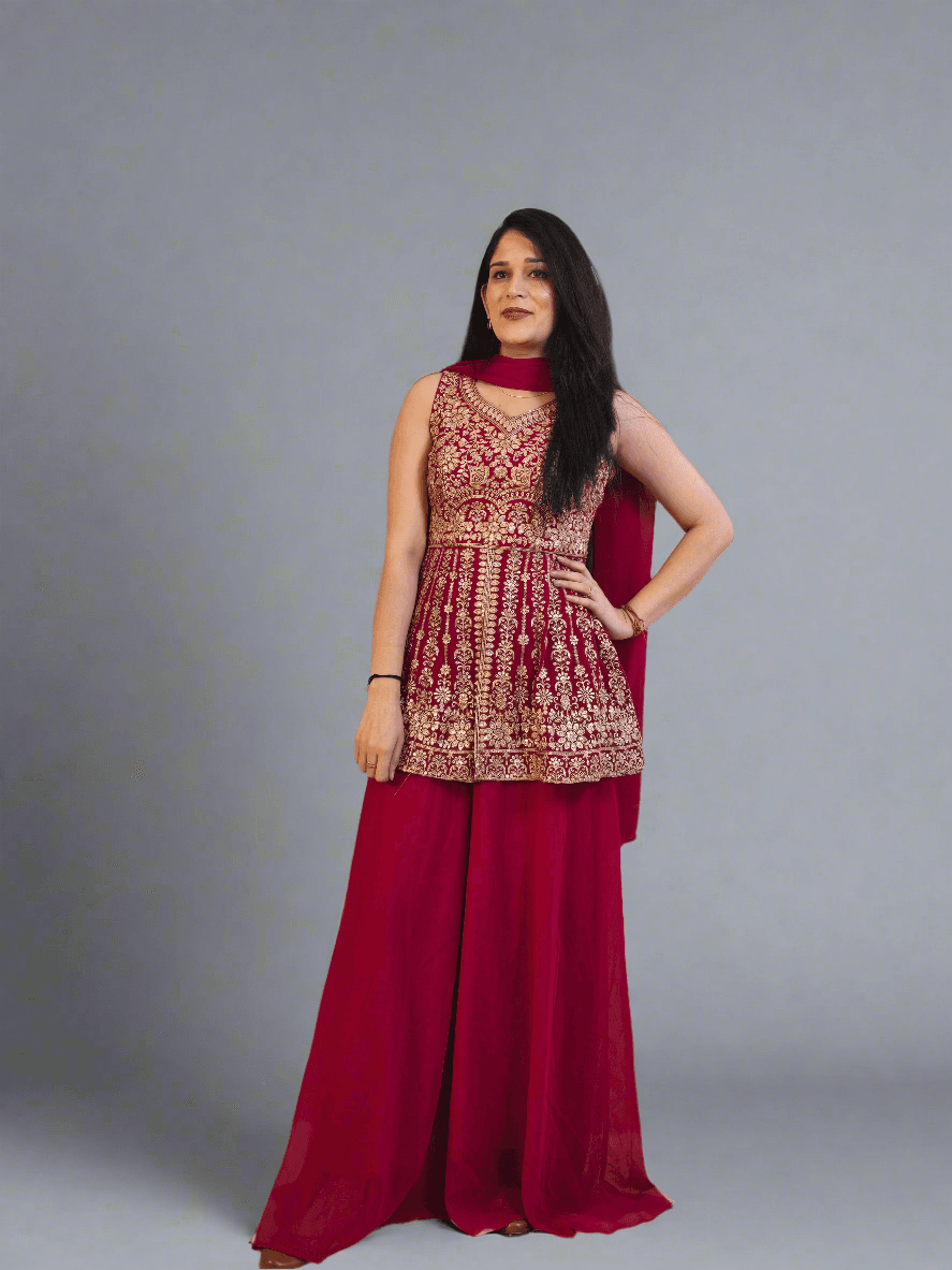 Woman in a red and gold dress lying on a textured floor with a colorful painting in the background.