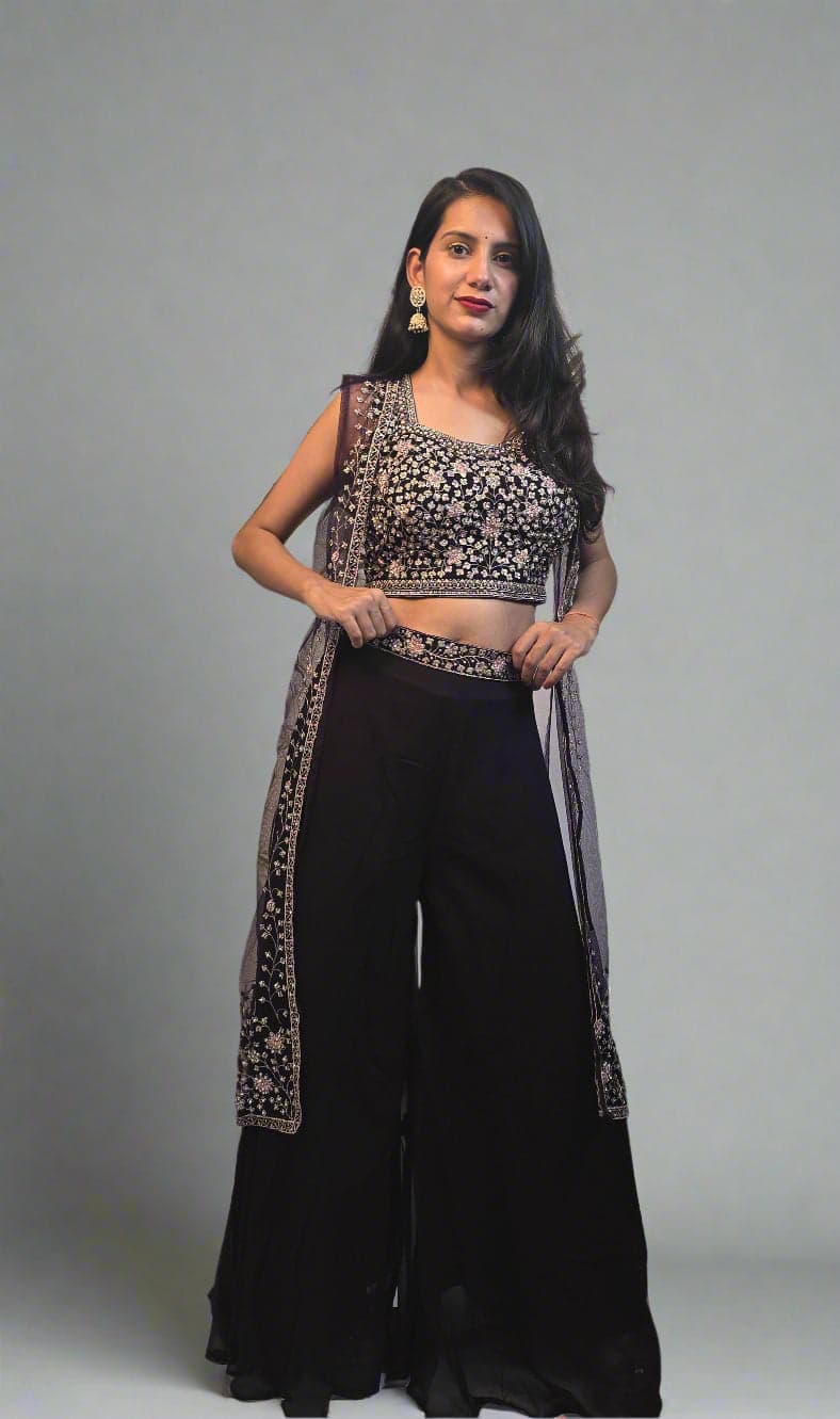 Woman in a black and white traditional outfit with plants in the foreground