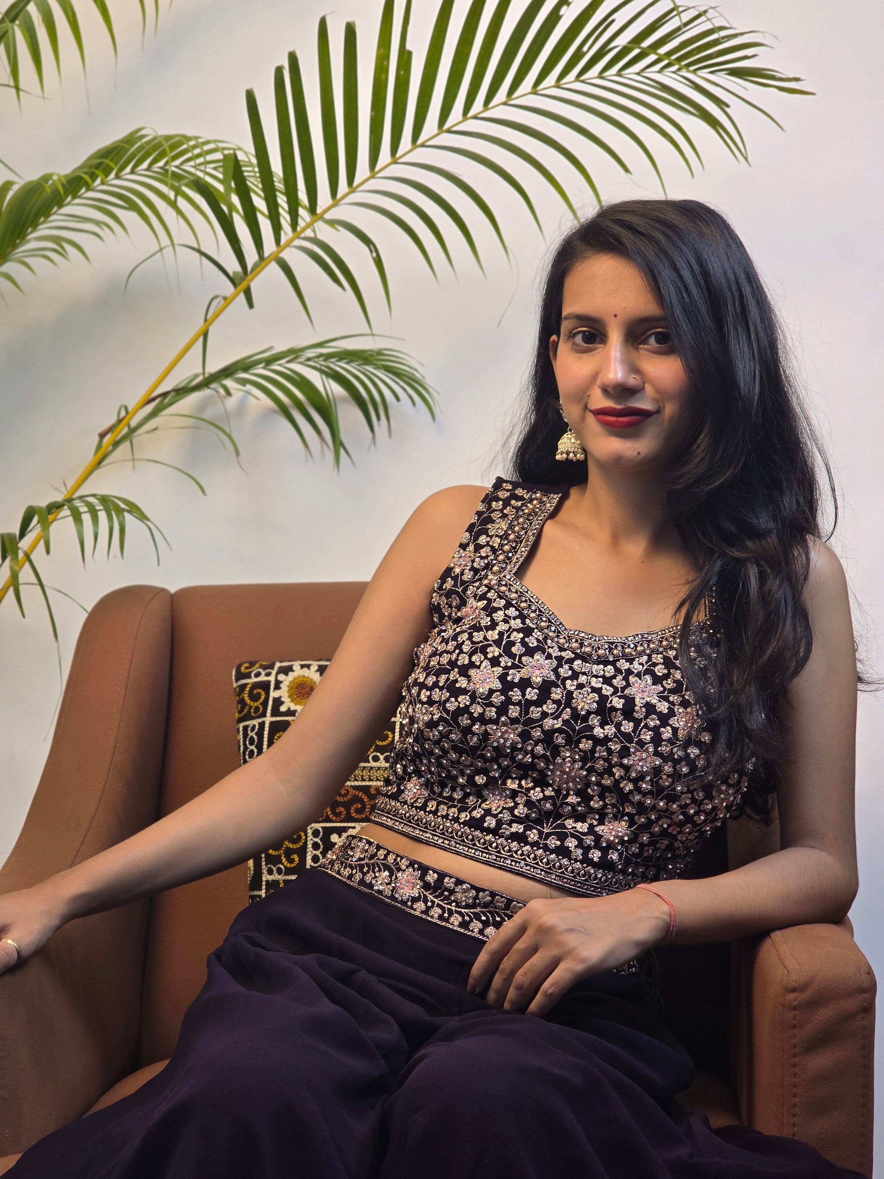 Woman in a black and white traditional outfit with plants in the foreground