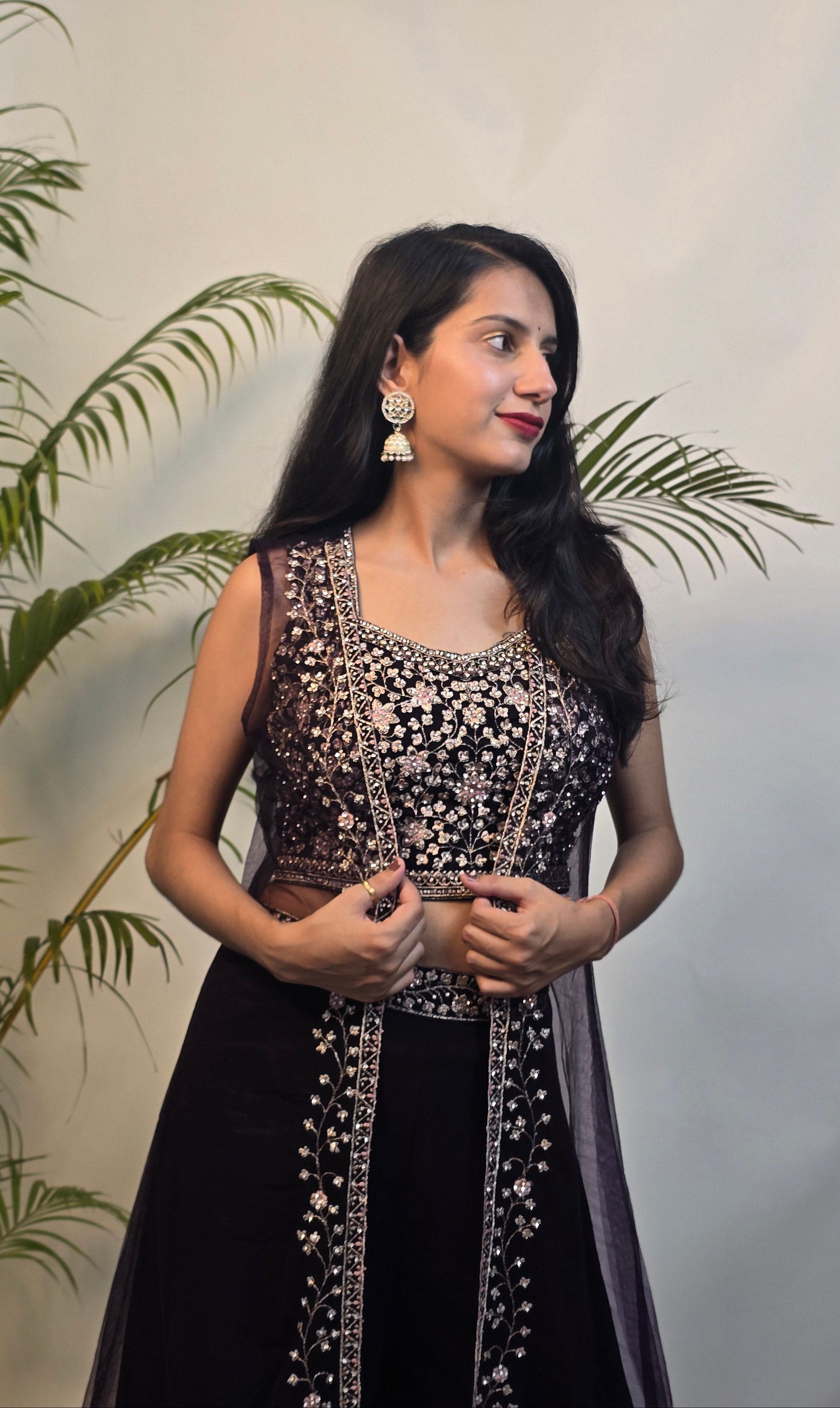 Woman in a black and white traditional outfit with plants in the foreground
