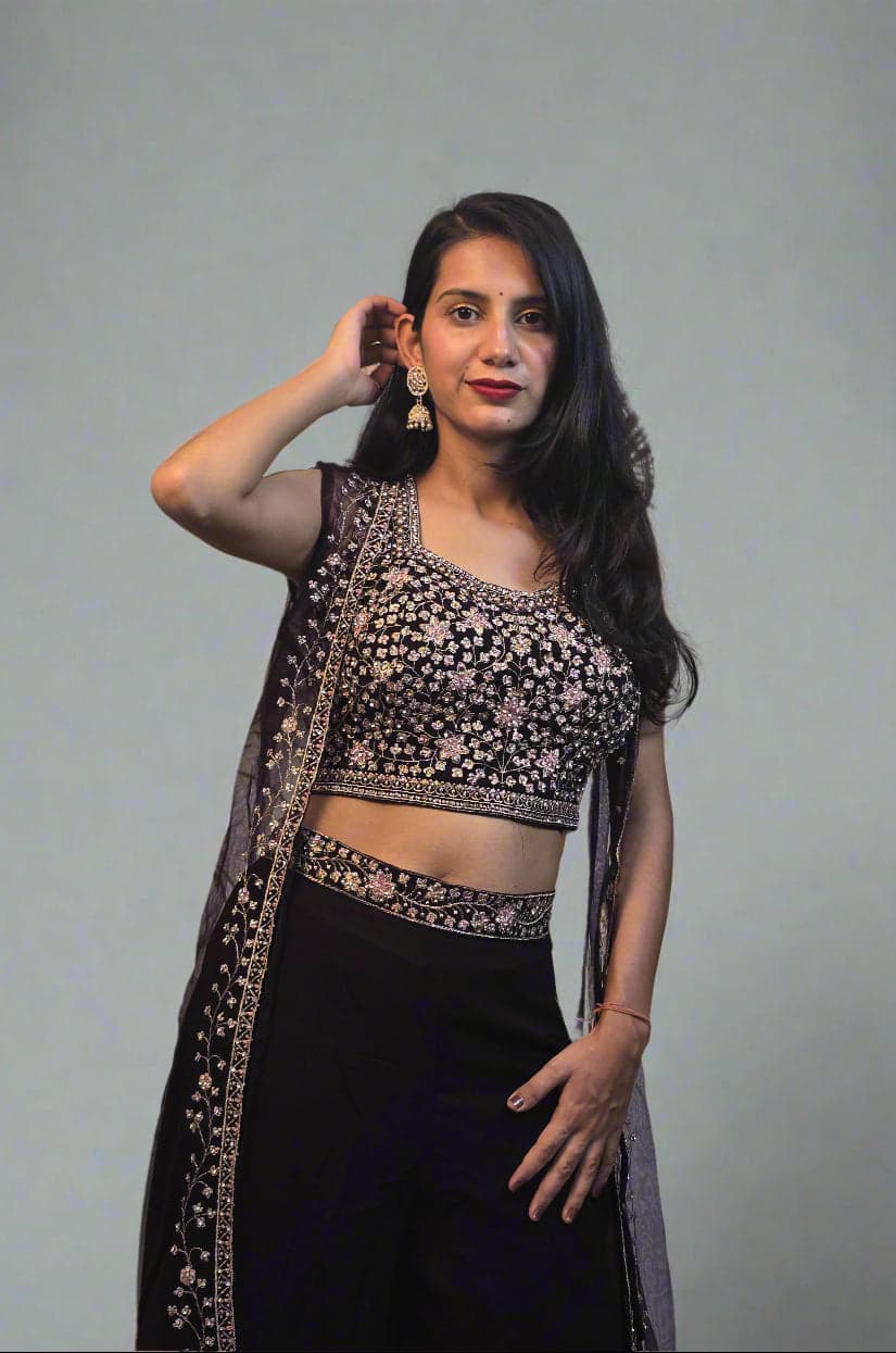 Woman in a black and white traditional outfit with plants in the foreground