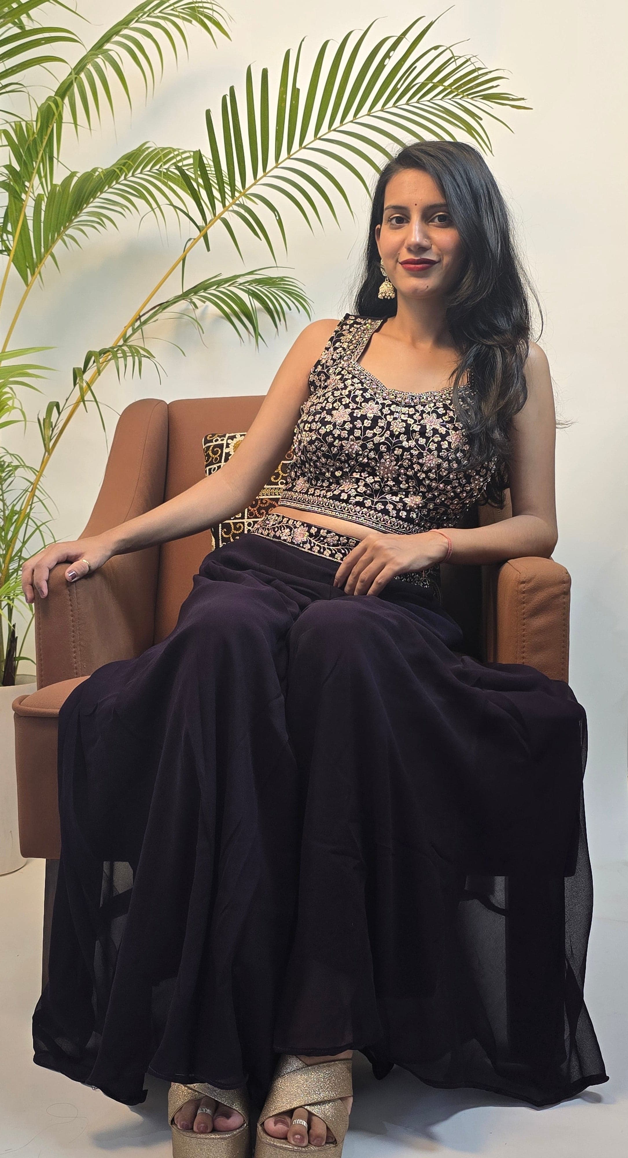Woman in a black and white traditional outfit with plants in the foreground