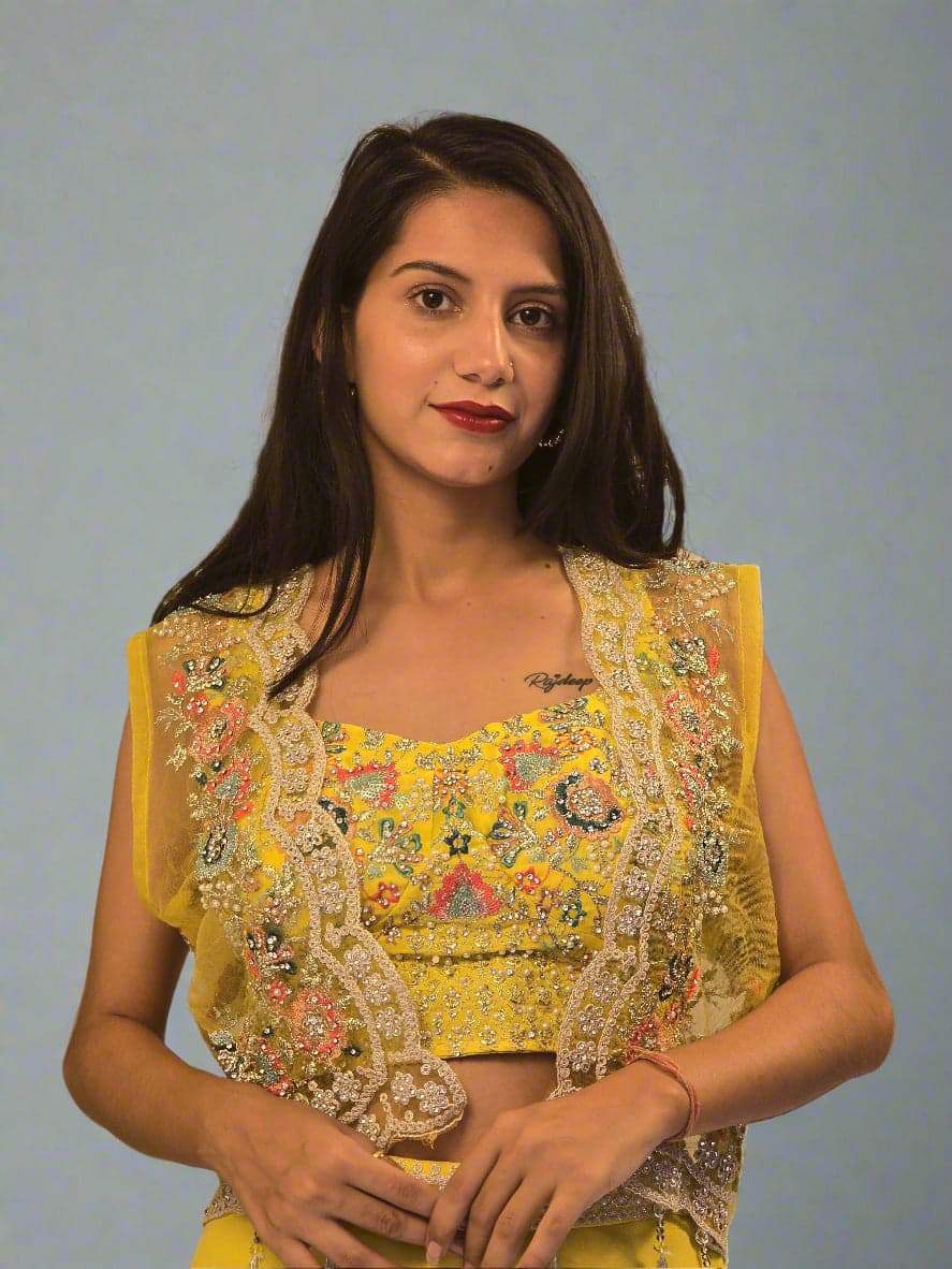 Woman wearing a yellow embroidered traditional outfit with a beige background