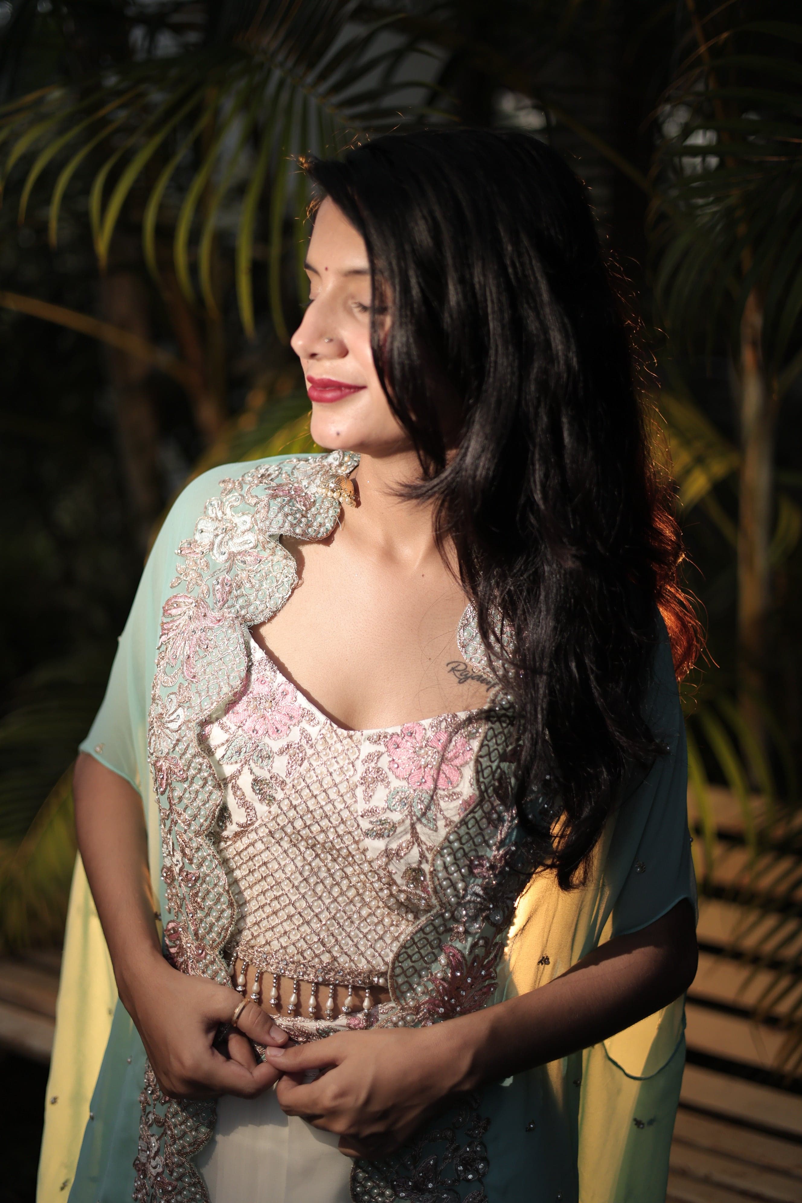 Woman lying on a surface with a textured top and dark hair, surrounded by greenery.