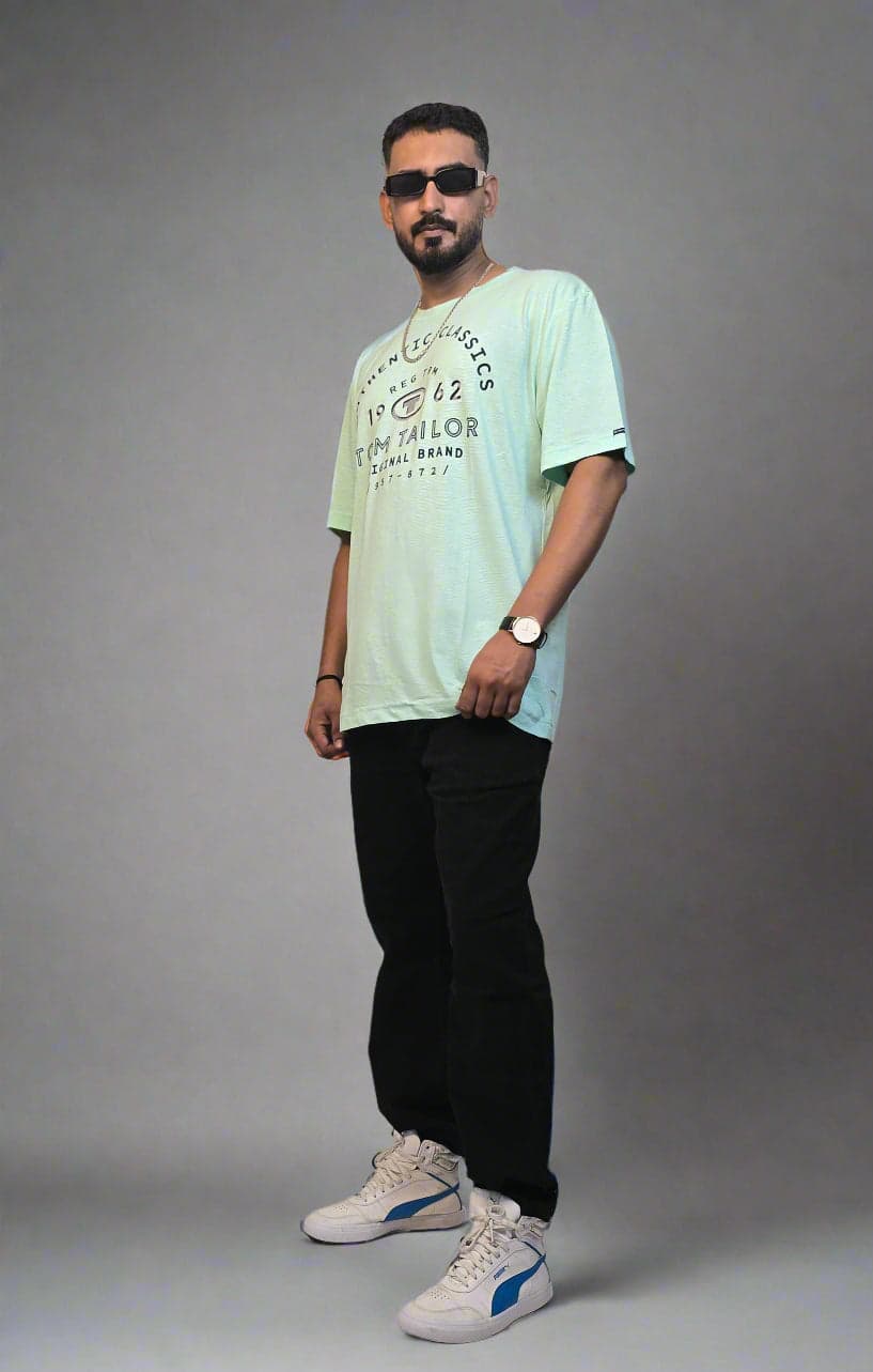 Person standing next to a plant on a white floor with a white wall background