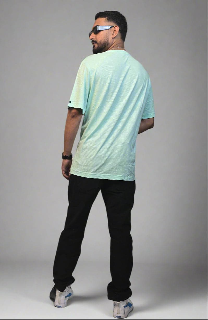 Person standing next to a potted plant indoors