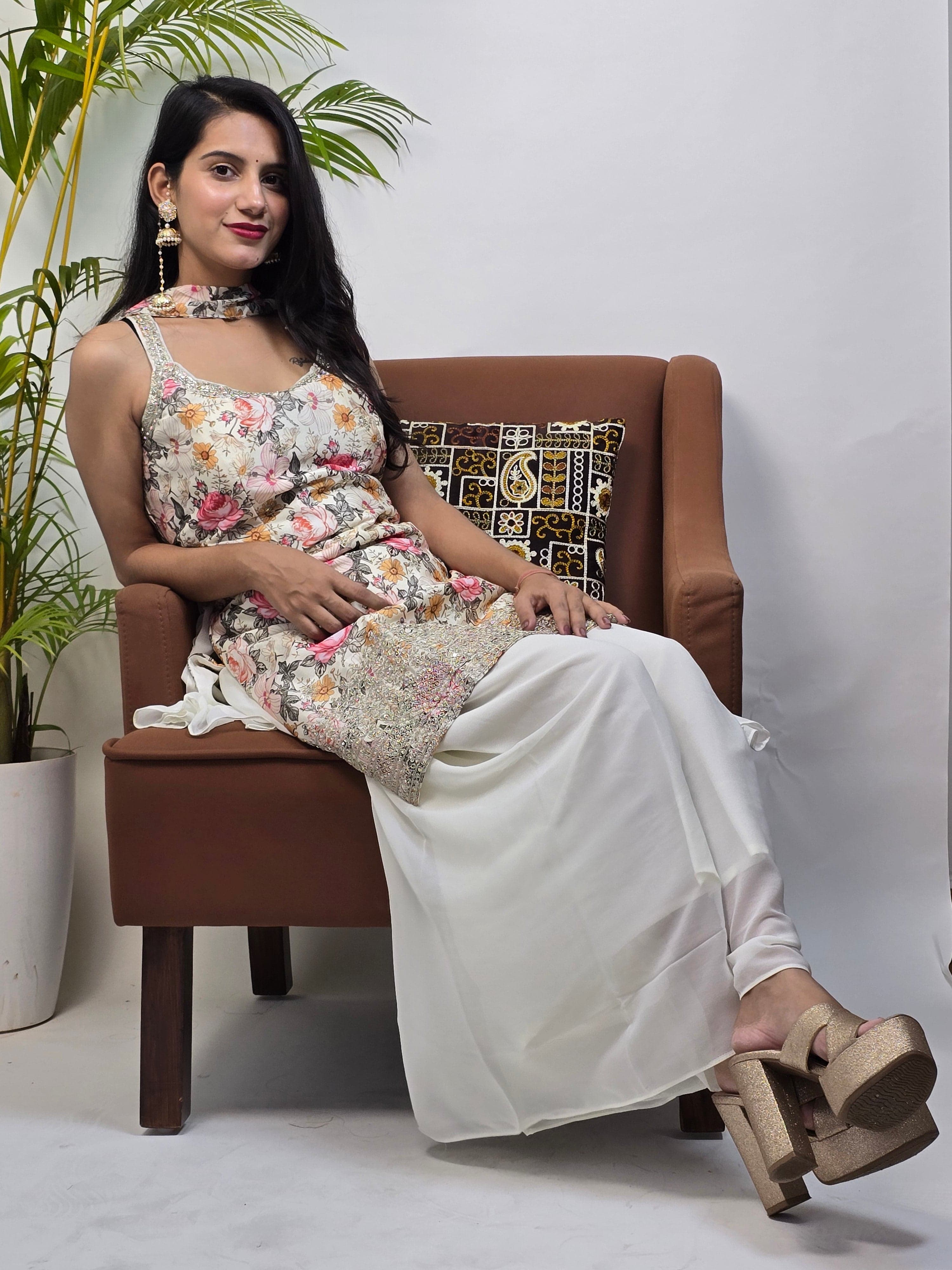 Woman sitting on a chair with a floral dress, holding a pillow.